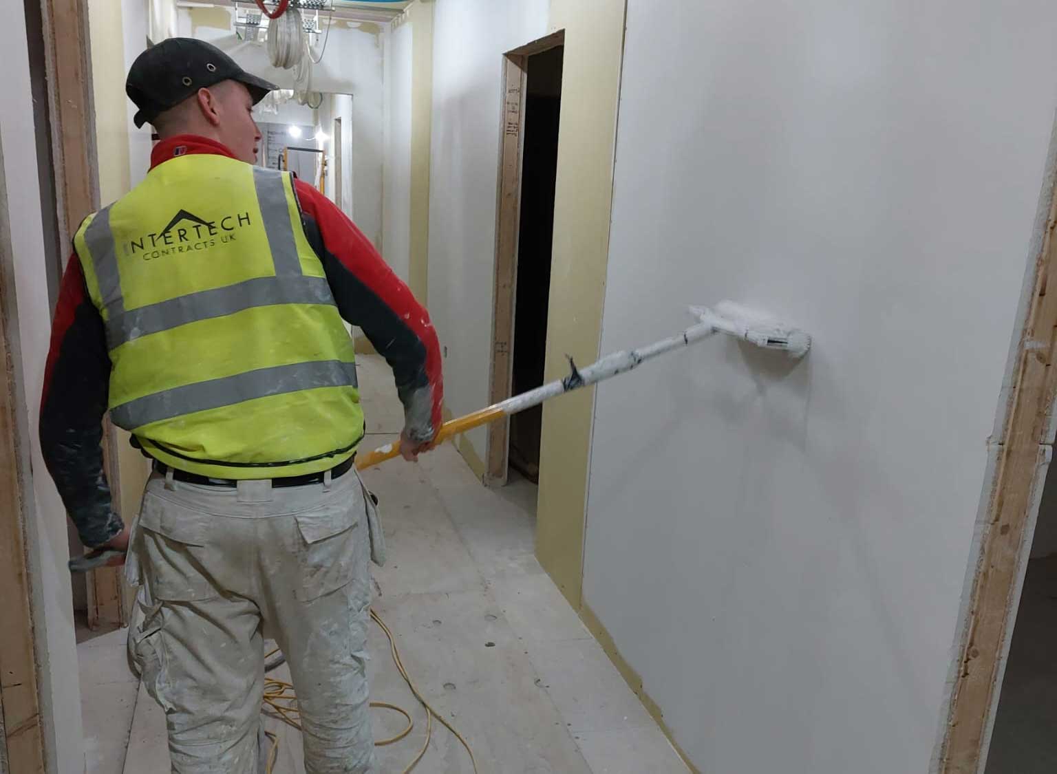 Apprentice using a paint roller